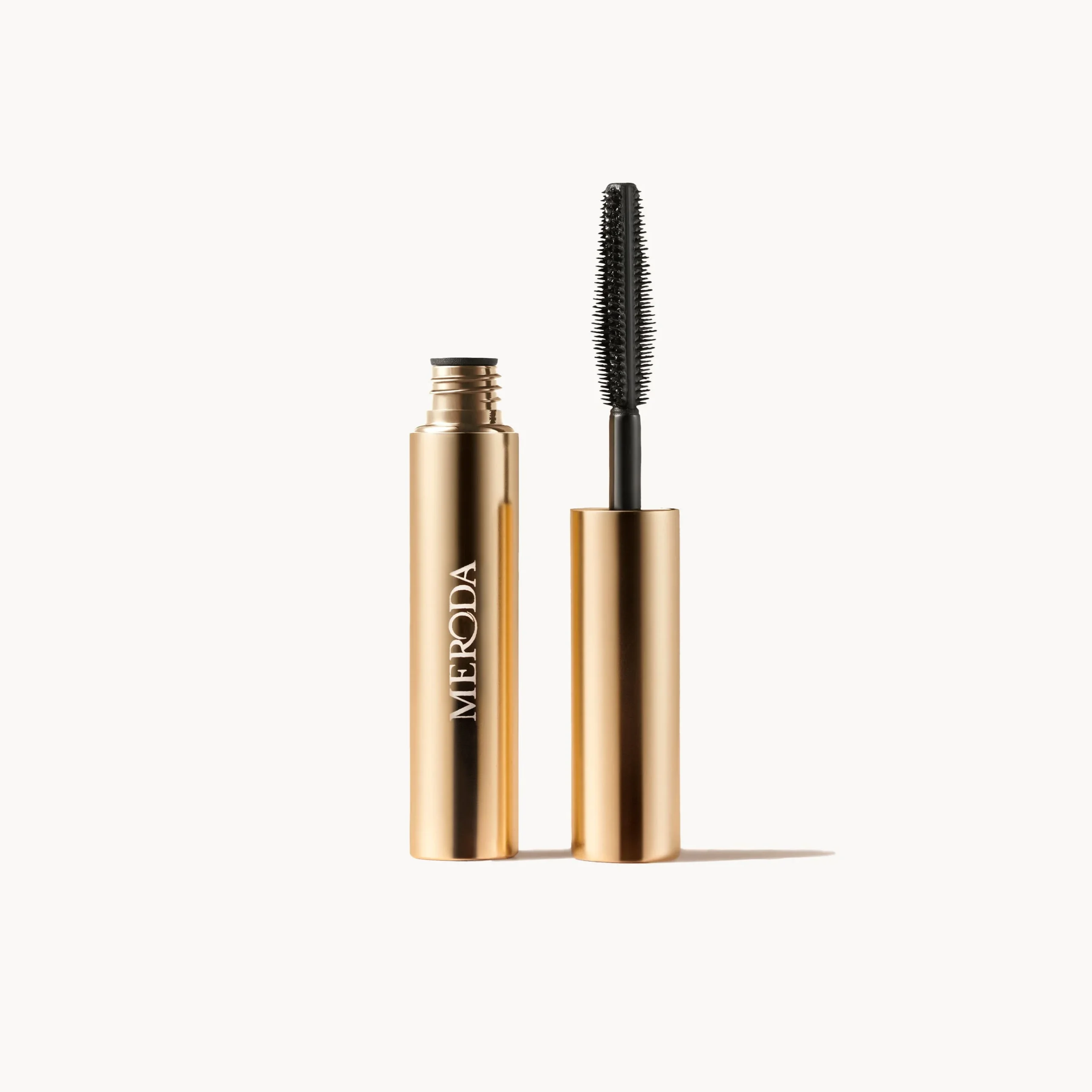 Meroda Cosmetics Gilded Lashes Mascara Sample 2 ml featuring an open gold tube and wand for length and volume