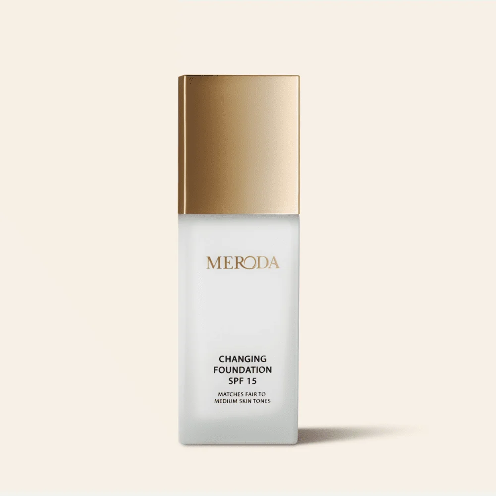 Meroda Cosmetics Changing Foundation SPF 15 bottle featuring a metallic gold cap and color-adapting pigments.