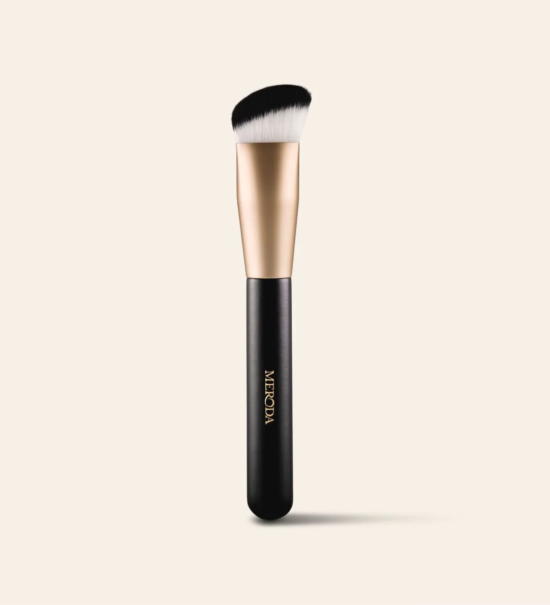 The Essential Brush with a black handle and triangular shape featuring dense bristles for precise, seamless application.