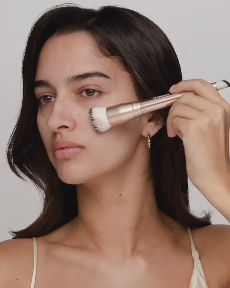 Applying Changing Foundation with the dual-ended 2-in-1 Build & Conceal Brush for a flawless complexion.