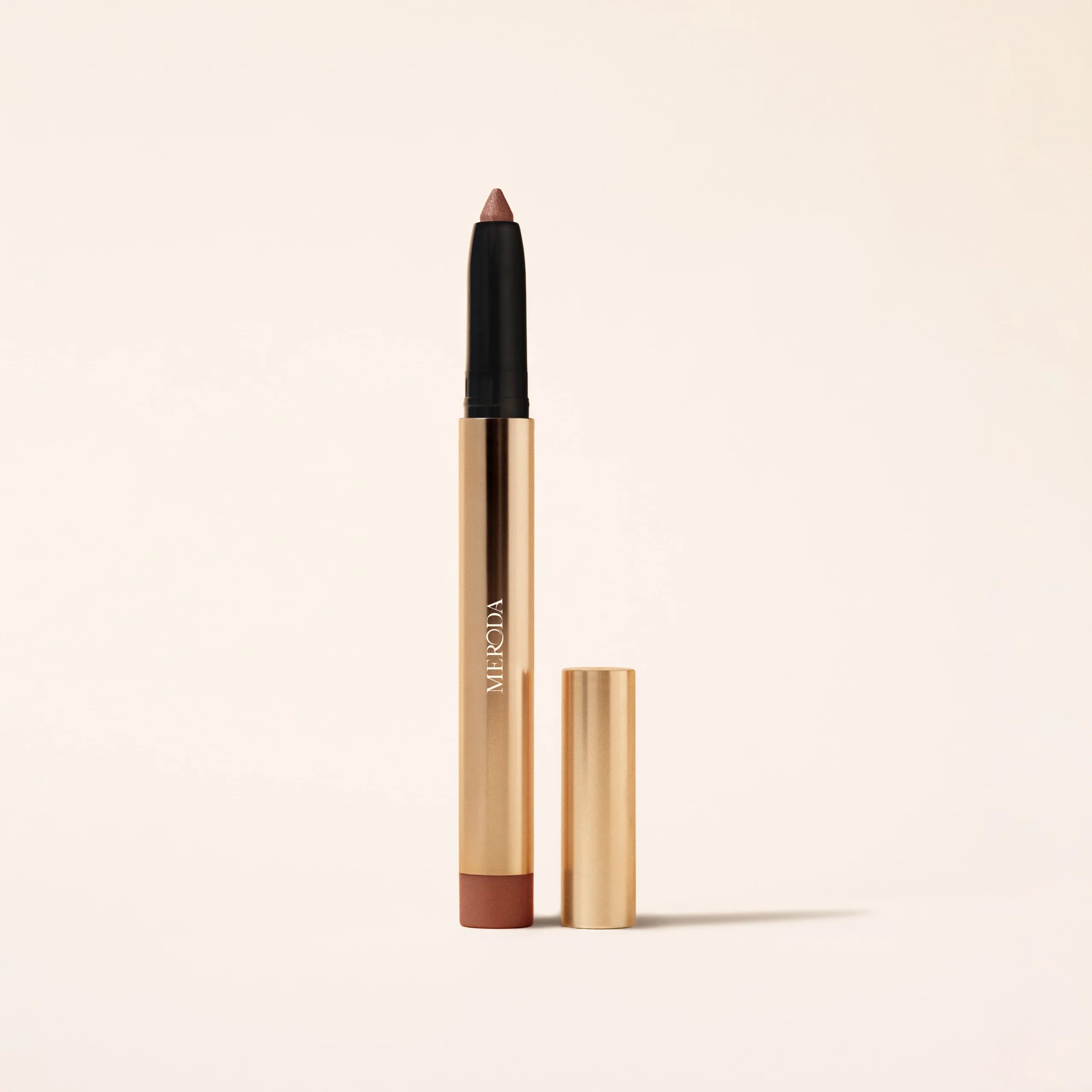 Meroda Cosmetics Eye Perfecting Shimmer Stick in Mauve featuring a shimmering tip and sleek gold metallic packaging.
