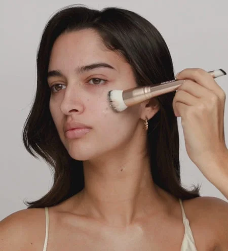 Model applies Meroda Changing Foundation with a 2-in-1 Build & Conceal Brush for a natural, seamless finish.