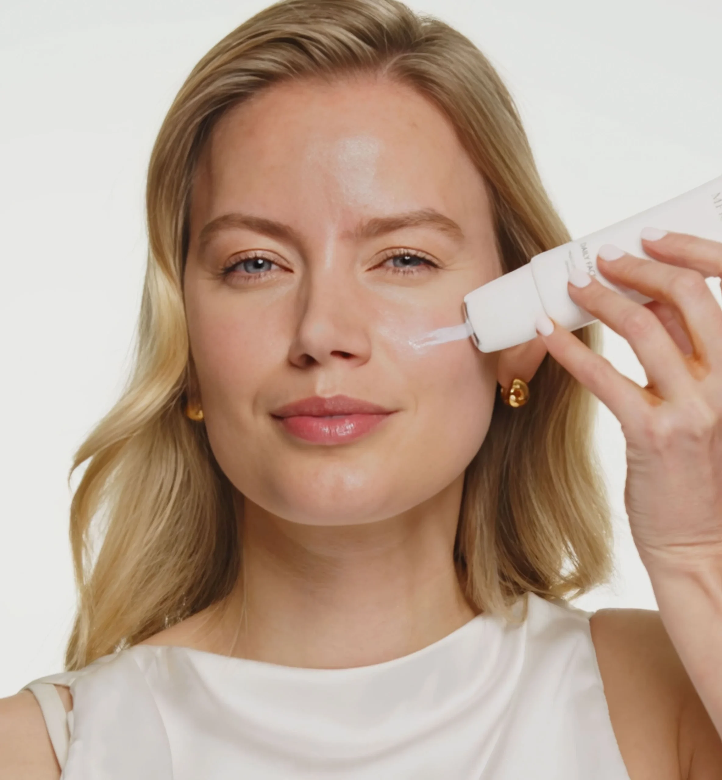 Daily Face SPF 40 being applied to a model's cheek using the roller applicator for skin protection.