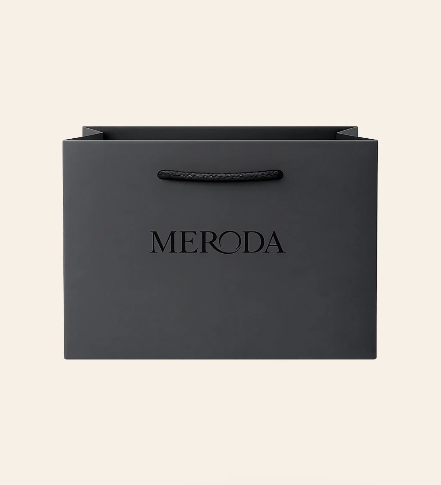 Gift Bag in matte black featuring a woven rope handle and embossed Meroda logo on a cream background.