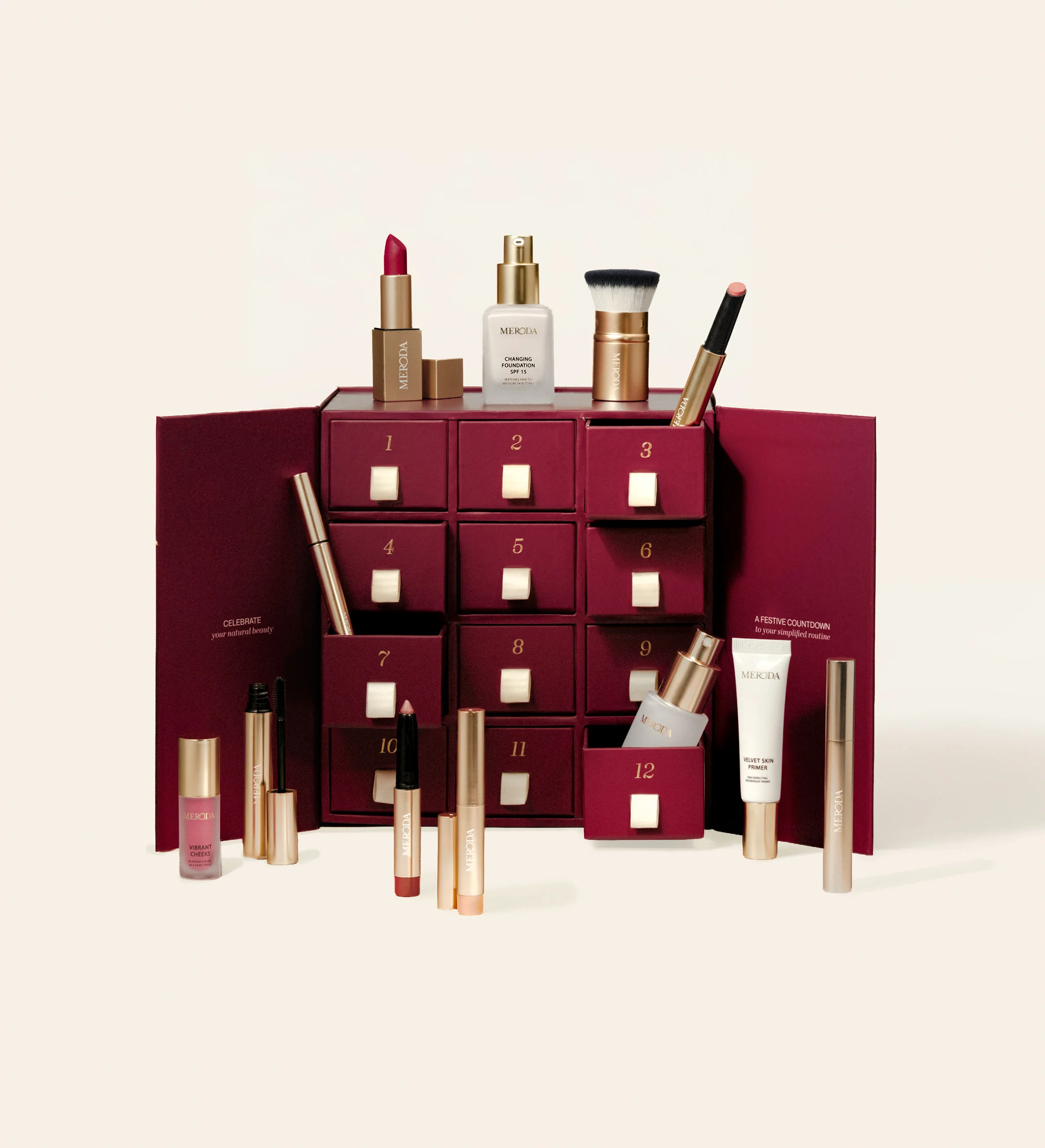 Advent Calendar - 12 Days of Effortless Beauty featuring a burgundy box with drawers and assorted makeup products displayed on cream.